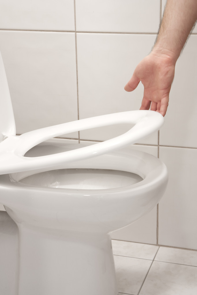 man lifting up toilet seat