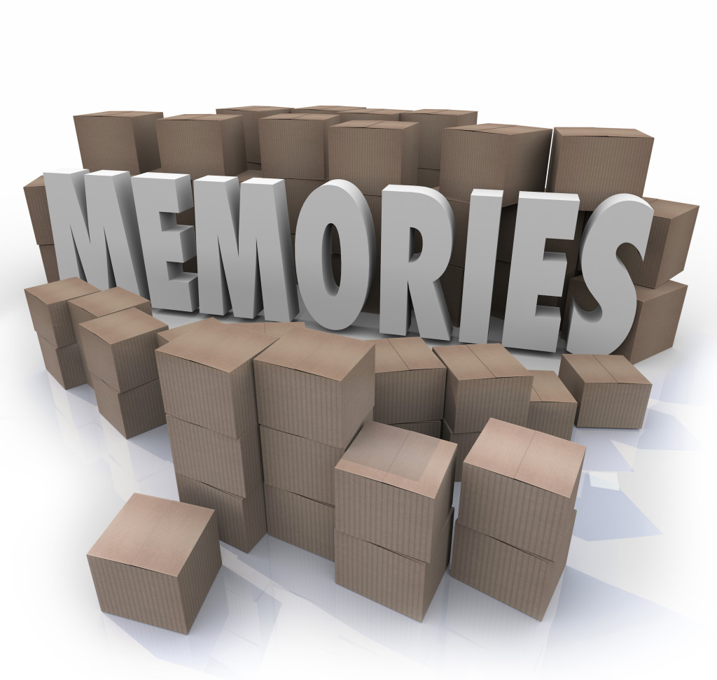 Memories word in 3d letters surrounded by cardboard boxes of items from your past history
